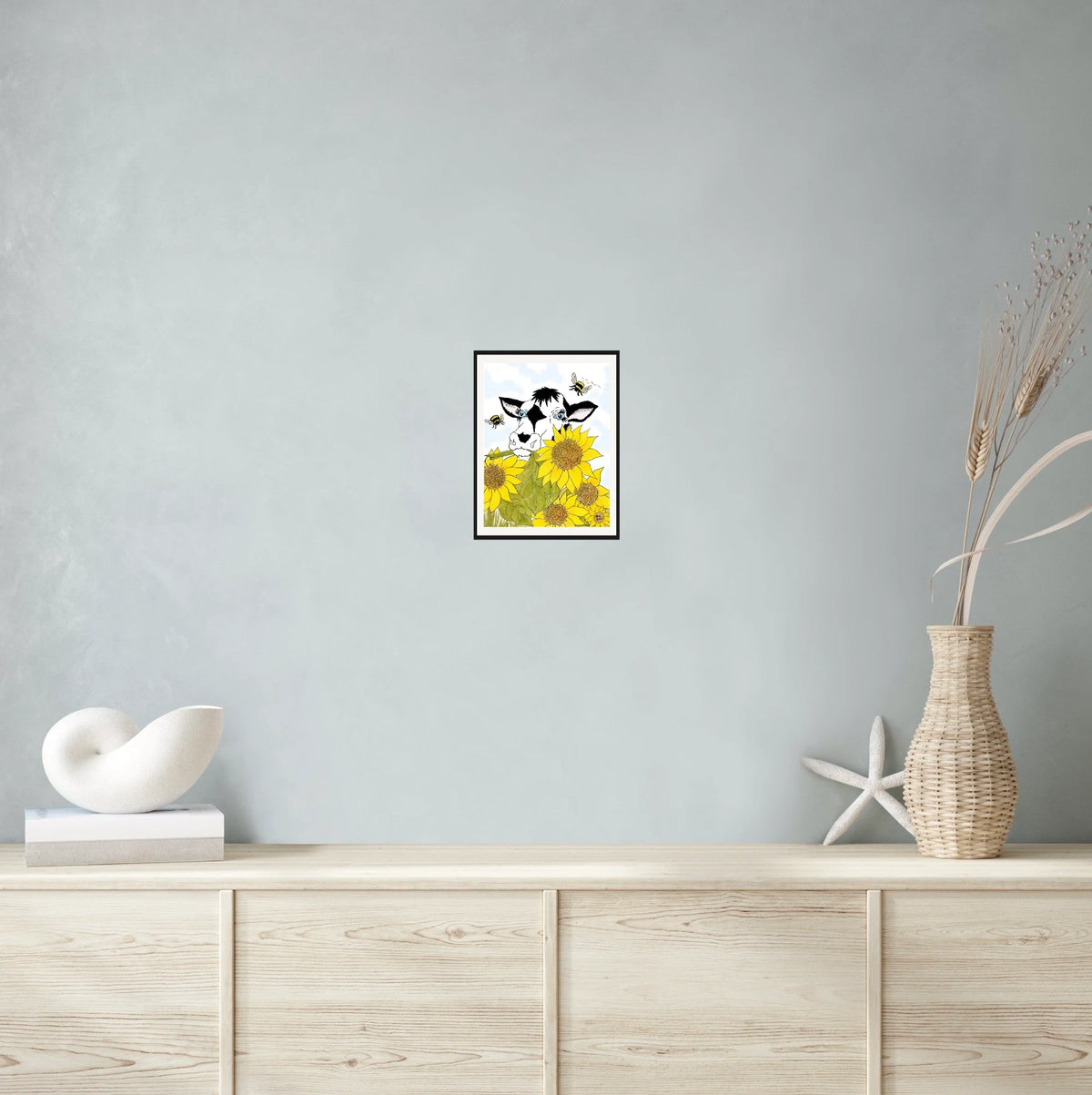 Bella Cow Among Sunflowers - medium 12 x 16 matted and framed art print shown hanging on a wall