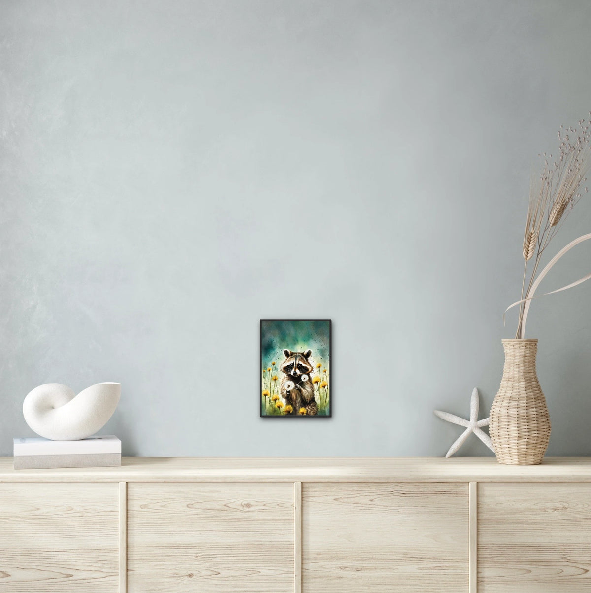 Raccoon Among Dandelions - medium 12 x 16 framed art print shown hanging on a wall
